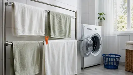 Nyvaskede håndklær på tørkestativ ved vaskemaskin